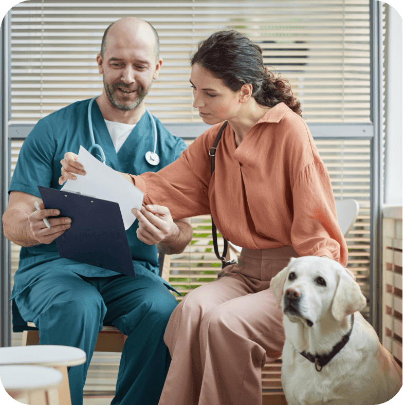 A woman talking to a veterinarian while holding a medical prescription